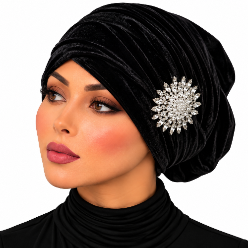 A close-up of a woman wearing a black velvet turban-style headwrap with a large sparkling silver rhinestone brooch on the side, against a plain white background.
