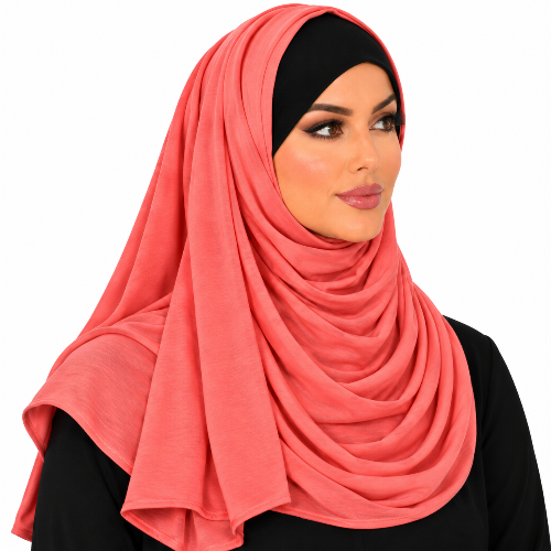 A woman wearing a coral pink chiffon hijab draped elegantly over her shoulders and a black under-cap, shown against a plain white background.