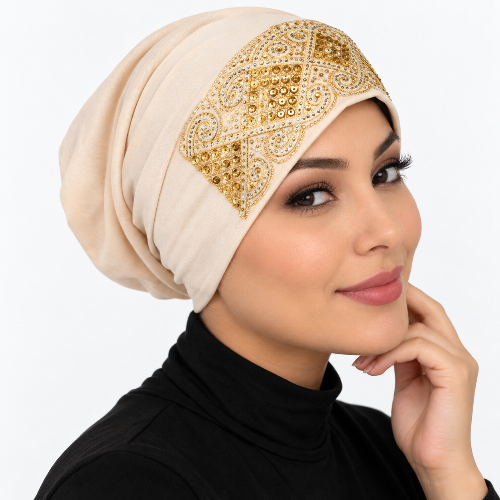 Cream gold underscarf cap with ornate gold embellished front design modeled on a woman against a clean white background.