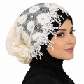 Cream pearl lace hijab cap with floral embroidery and beaded details worn by a model on a white background.