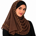 Woman wearing a brown chiffon hijab scarf with gold bead detail around the edge