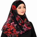 A woman wearing a black hijab with a vibrant red, pink, and orange floral print, shown against a plain white background.
