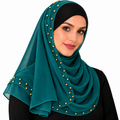 Woman wearing a teal chiffon hijab scarf with small gold beads on a white background