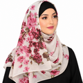 Woman wearing a beige pink floral hijab with pink burgundy and green flowers