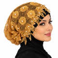Gold pearl lace hijab cap with floral lace and beaded details worn by a model on a white background.