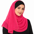 Woman wearing a hot pink hijab scarf with thin light gold trim on a white background
