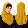 Mustard yellow pearl beaded hijab scarf for women with gold pearl details on the top and back, shown on a female model.