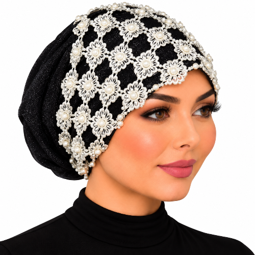 Woman modeling a black embellished turban with white floral lace and pearl bead details on a white background.