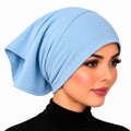 A woman wearing a light blue hijab-style head covering with a curved row of small rhinestone embellishments across the front, shown against a plain white background.