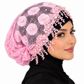 Pink pearl lace hijab cap with floral lace, pearl embellishments, and decorative beaded trim worn by a model on a white background.