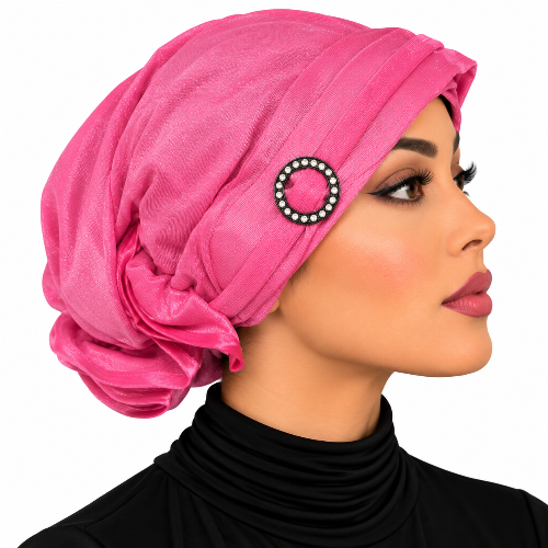Woman wearing a pink pre-tied turban cap with a rhinestone ring detail
