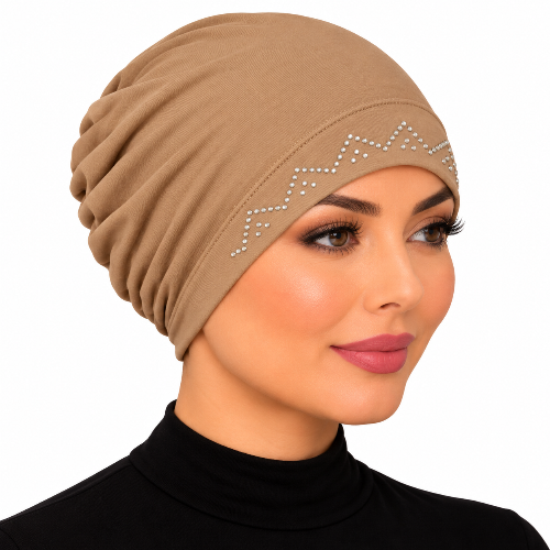 Woman modeling a beige stretch cap hijab with silver rhinestone zigzag trim on a white background.