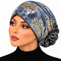 Woman wearing a silver turban with elegant gold floral pattern and ruffled back detail