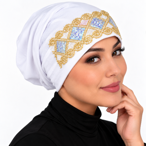 White underscarf cap with ornate gold and iridescent embellished front design modeled by a woman against a clean white background.